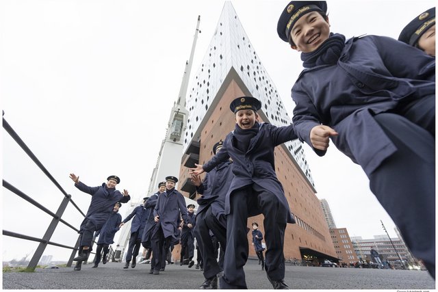 Schwungvolle Außenaufnahme von Lukas Beck in Hamburg: Die Wiener Sängerknaben posieren bester Laune in ihren traditionellen Matrosenuniformen direkt vor dem modernen Architektur-Wahrzeichen der Elbphilharmonie in der HafenCity. Hochgeladen im Juli 2026 von tb.