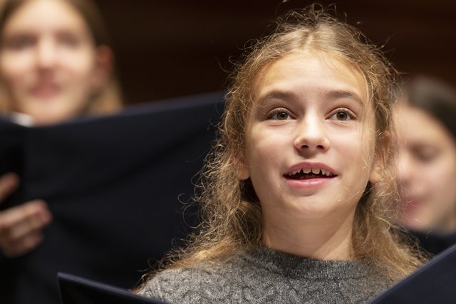 Mädchen singt im Chor.