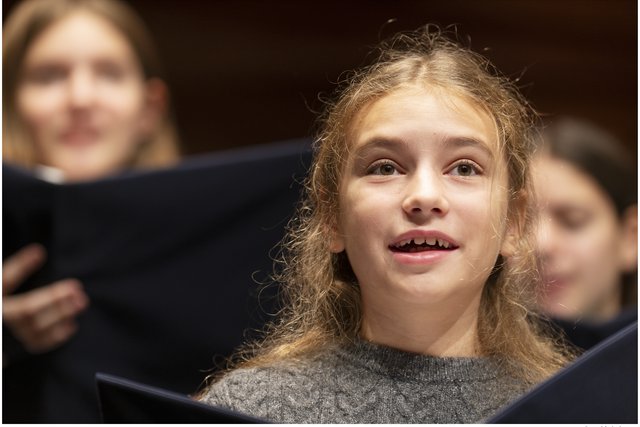 Mädchen singt im Chor.